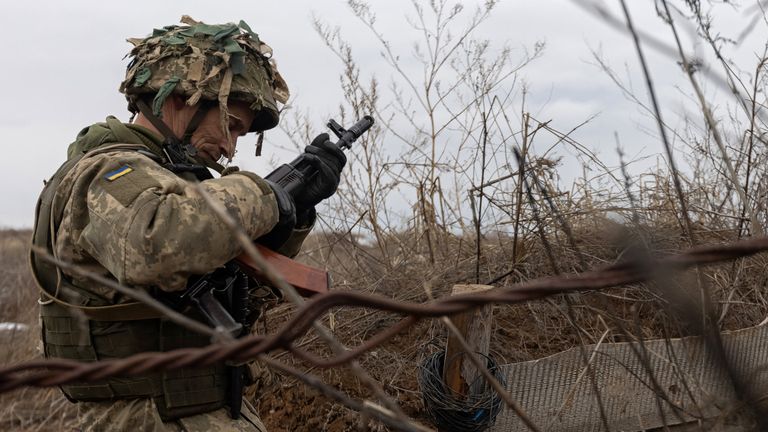 A service member of the Ukrainian armed forces stands guard at combat positions near the line of separation from Russian-backed rebels near Horlivka in Donetsk Region, Ukraine, January 9, 2022. REUTERS/Andriy Dubchak