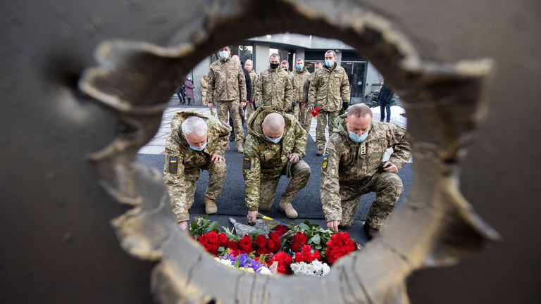 People attend a ceremony in tribute to fallen defenders of Ukraine, including the soldiers killed during a battle with pro-Russian rebels for the Donetsk airport this day in 2015, at a memorial near the headquarters of the Defence Ministry in Kyiv, Ukraine January 20, 2022. Ukrainian Presidential Press Service/Handout via REUTERS ATTENTION EDITORS - THIS IMAGE WAS PROVIDED BY A THIRD PARTY.
