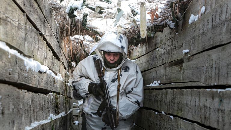 An armed serviceman walks along a trench on the territory controlled by pro-Russian militants on the frontline with Ukrainian government forces near Spartak village in Yasynuvata district of Donetsk region, eastern Ukraine. Pic: AP