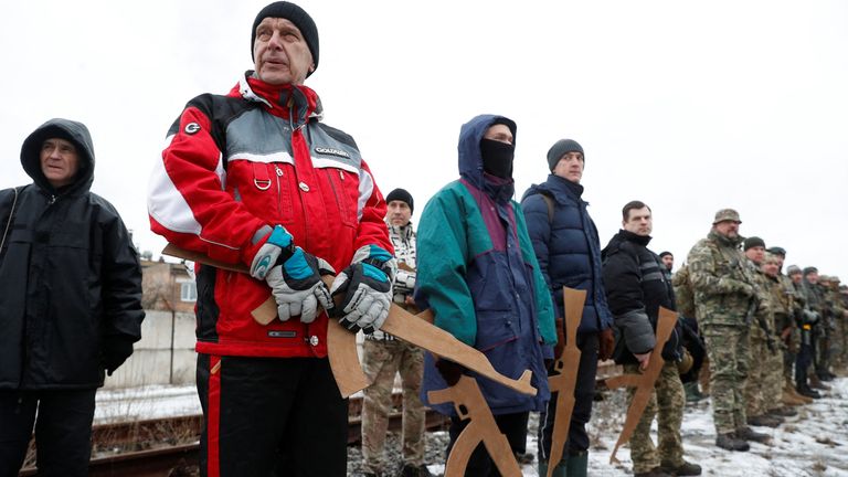 Des réservistes ukrainiens ont utilisé des morceaux de bois en forme de fusils lors d'exercices militaires à la périphérie de Kiev