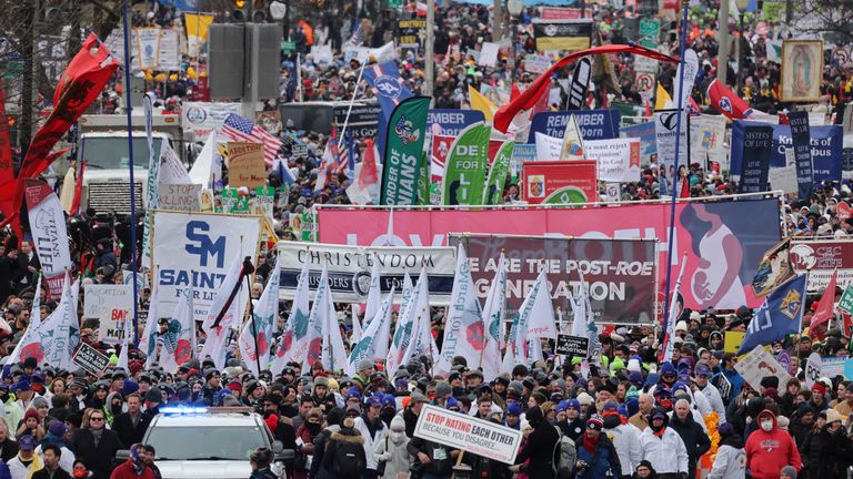 مردم هنگام راه رفتن در طول سال بنرها و پرچم ها را در دست دارند "مارس برای زندگی"، در واشنگتن، ایالات متحده آمریکا، 21 ژانویه 2022. رویترز / جیم بورگ