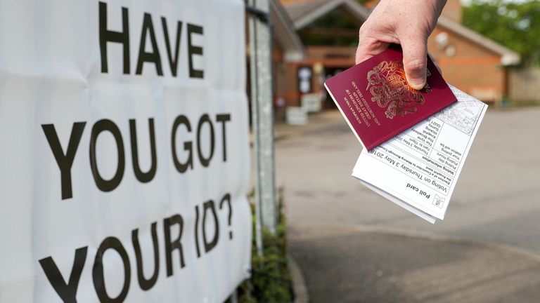 A voter carries his passport along with his poll card at The Vyne polling station in Knaphill, part of the Woking borough, which was one of five councils that trialed the use of ID in polling stations in May 2018