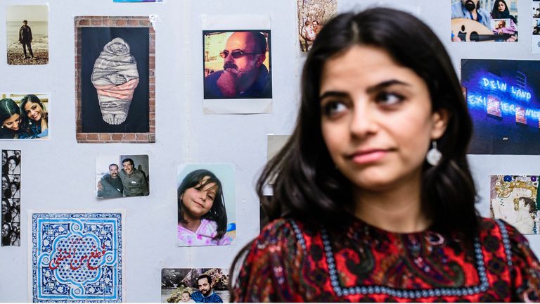 Syrian activist, journalist, and artist living in exile in Germany, Wafa Ali Mustafa, poses for a photo in front of a photo wall prior to an interview in Berlin, Germany, 03 March 2021