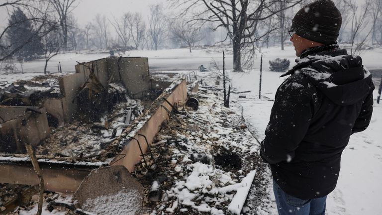 Chris Dreier looks at his house burned by wildfires, a day after evacuation orders, in Louisville, Colorado