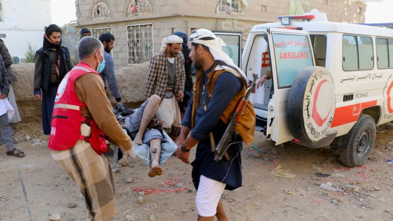 Rescuers carry an injured man at the scene where air strikes hit, on a detention center in Saada, Yemen Jaunary 21, 2022. REUTERS/Naif Rahma
