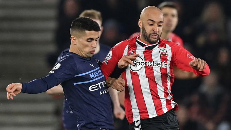 Joao Cancelo competes for possession with Nathan Redmond