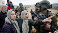 Palestinian women react next to Israeli soldiers as an Israeli machinery demolishes an under-construction house, in Hebron, in the Israeli-occupied West Bank, December 28, 2021. REUTERS/Mussa Qawasma