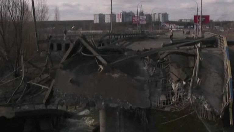 Residents struggle to climb over the rubble of a collapsed bridge as Russian attacks on Ukraine continue. 