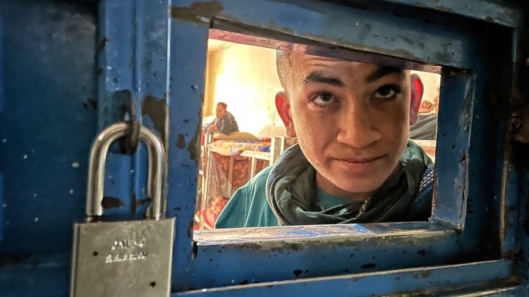 A teenage boy looks out from his cell in Herat Prison






