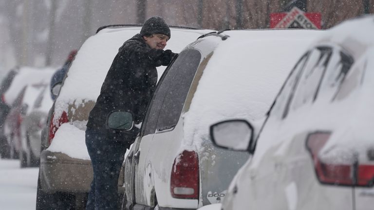 A motorist cleans his vehicle of snow, Thursday, Feb. 3, 2022, in Indianapolis.  A major winter storm with millions of Americans in its path is spreading rain, freezing rain and heavy snow further across the country. (AP Photo/Darron Cummings) 