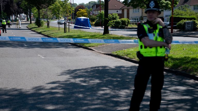 A police officer stands near the scene on College Road, Kingstanding after Dea-John Reid was stabbed