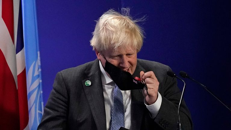 British Prime Minister Boris Johnson takes off his mask as he prepares to speak at the COP26 U.N. Climate Summit, in Glasgow, Scotland, Tuesday, Nov. 2, 2021. The U.N. climate summit in Glasgow gathers leaders from around the world, in Scotland&#39;s biggest city, to lay out their vision for addressing the common challenge of global warming. (AP Photo/Alberto Pezzali)..