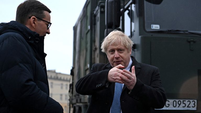 Britain&#39;s Prime Minister Boris Johnson (R) speaks with Polish Prime Minister Mateusz Morawiecki (L) during a visit to Warszawska Brygada Pancerna military base near Warsaw, Poland February 10, 2022. Daniel Leal/Pool via REUTERS
