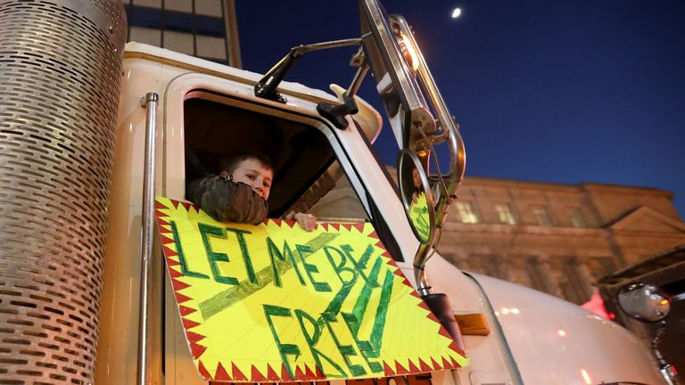 A child looks on from the window of a truck as truckers and supporters protest against coronavirus disease (COVID-19) vaccine mandates, in Toronto, Ontario, Canada, February 5, 2022. REUTERS/Carlos Osorio
