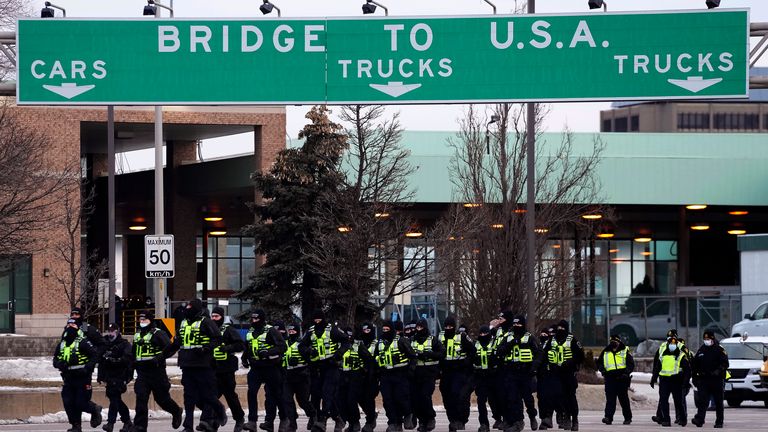 Police move into position to enforce an injunction against a demonstration which has blocked traffic across the Ambassador Bridge by protesters against COVID-19 restrictions, in Windsor, Ont., Saturday, Feb. 12, 2022. THE CANADIAN PRESS/Nathan Denette