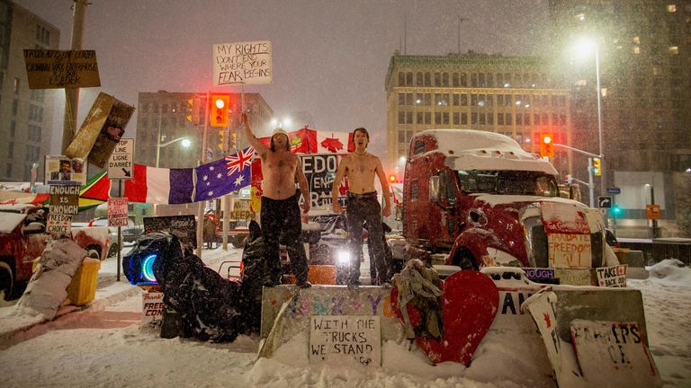 Two people scream while dancing, as protests against coronavirus disease (COVID-19) vaccine mandates continue, along Wellington street near the Parliament of Canada, in Ottawa, Ontario, Canada, February 17, 2022. Picture taken February 17, 2022. REUTERS/Carlos Osorio
