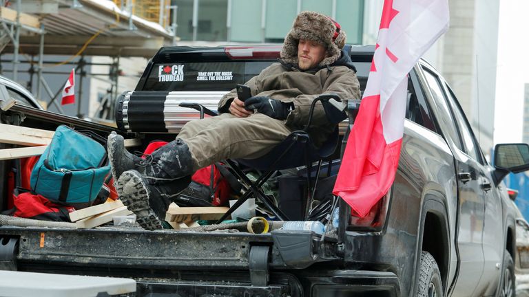A man relaxes in his pickup truck as truckers and supporters continue to protest against the COVID-19 vaccine mandates in Ottawa, Ontario, Canada, February 6, 2022. REUTERS/Patrick Doyle
