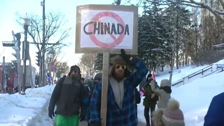 A man holds a sign that reads &#39;Chinada&#39; during a protest against Canadian vaccine mandates. 