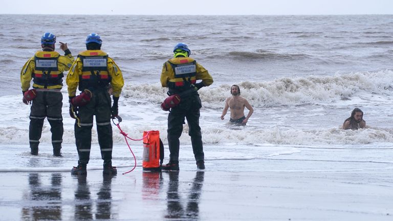 A coastguard search and rescue team ask a group of swimmers to come out of the sea in New Brighton, Merseyside, as Storm Eunice hits the south coast, with attractions closing, travel disruption and a major incident declared in some areas, meaning people are warned to stay indoors. A rare red weather warning - the highest alert, meaning a high impact is very likely - has been issued by the Met Office due to the combination of high tides, strong winds and storm surge. Picture date: Friday February