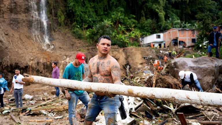People remove debris following a landslide caused by heavy rains, that killed and injured residents and destroyed homes, in Pereira, Colombia, February 8, 2022. REUTERS/Vladimir Encina Duque NO RESALES. NO ARCHIVES REFILE - QUALITY REPEAT
