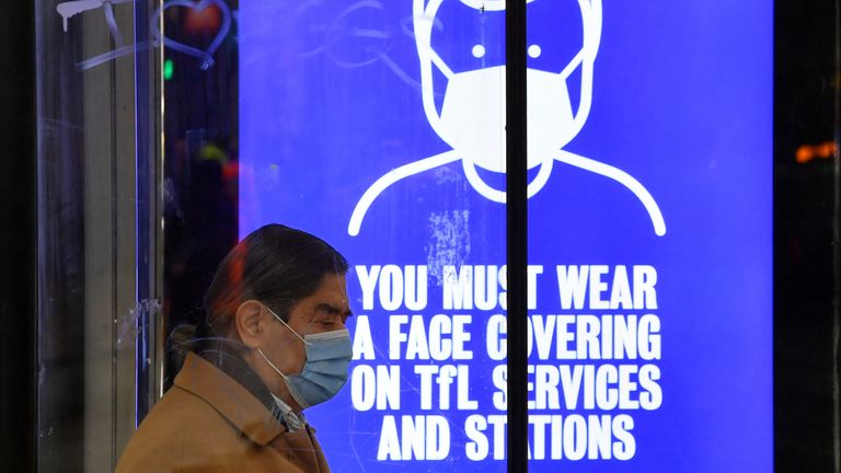 A person wearing a protective face mask waits at a bus stop, as rules on wearing face coverings in some settings in England are relaxed, amid the spread of the coronavirus disease (COVID-19) pandemic, in London, Britain, January 27, 2022. REUTERS/Toby Melville
