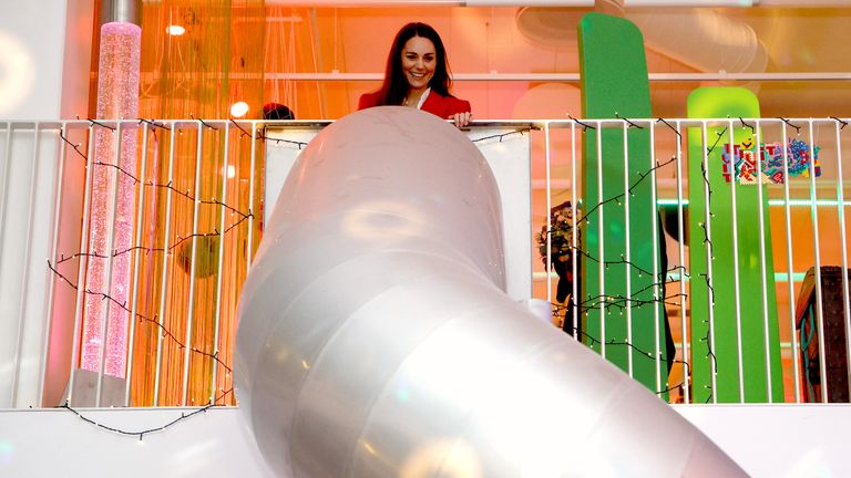 Księżna Cambridge stoi na górze slajdu, zanim użyje go podczas wizyty w fundacji Lego PlayLab