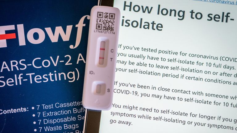 A positive lateral flow test cassette placed next to advice from the NHS website, in London. The UK Health Security Agency have said people in England may be able to leave self-isolation on or after day 6 of your self-isolation period if you have 2 negative tests on day 5 and 6. Picture date: Monday January 17, 2022.