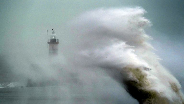 A wave crashes over Newhaven lighthouse at West Quay in East Sussex. Feb 20