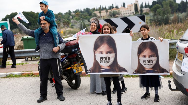 Children hold signs which read "freedom doesn&#39;t look like this" as part of a protest before heading to Jerusalem as part of an Israeli "Freedom Convoy", to protest against restrictions to contain the spread of the coronavirus disease (COVID-19), in Latrun, Israel, February 14, 2022. REUTERS/Amir Cohen