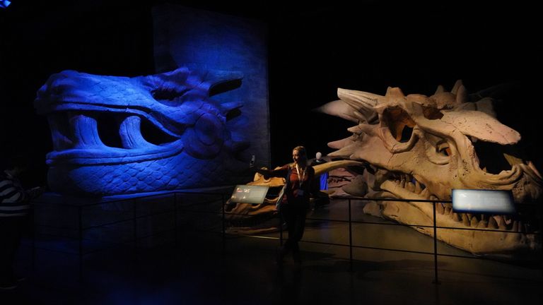 A woman takes selfies next to dragon skulls during the preliminary day of the Game of Thrones Studios tour at Linen Mill Studios in Banbridge, Northern Ireland, which opens to the public on February 4. Date of the photo: Wednesday, February 2, 2022