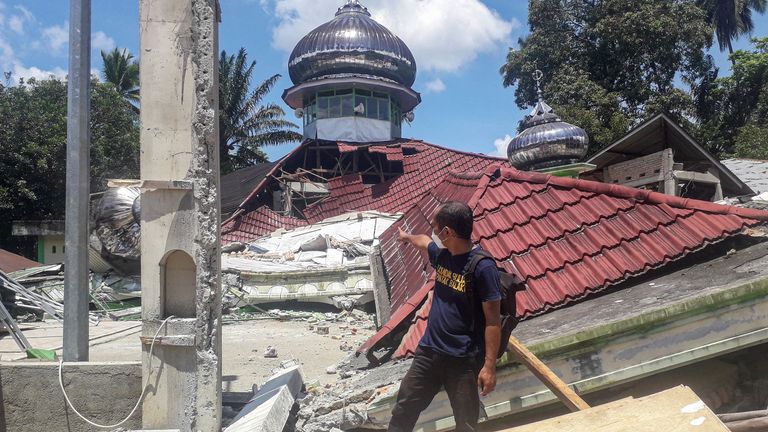 Seorang pria memeriksa kerusakan Masjid Raya Kajai yang hancur setelah gempa bumi di Kecamatan Talamau di pulau Sumatera, Indonesia 25 Februari 2022. Foto Antara/Altas Maulana via REUTERS ATTENTION EDITORS - GAMBAR INI DISEDIAKAN PIHAK KETIGA.  KREDIT WAJIB.  INDONESIA MATI.  TIDAK ADA PENJUALAN KOMERSIAL ATAU EDITORIAL DI INDONESIA.