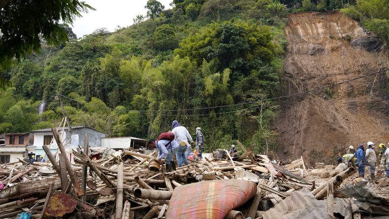 People remove debris following a landslide caused by heavy rains, that killed and injured residents and destroyed homes, in Pereira, Colombia, February 8, 2022. REUTERS/Vladimir Encina Duque NO RESALES. NO ARCHIVES
