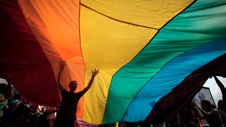 A man is seen underneath the rainbow flag during the the fourth gay pride rally in the Bulgarian capital of Sofia on Saturday, June 18, 2011. 