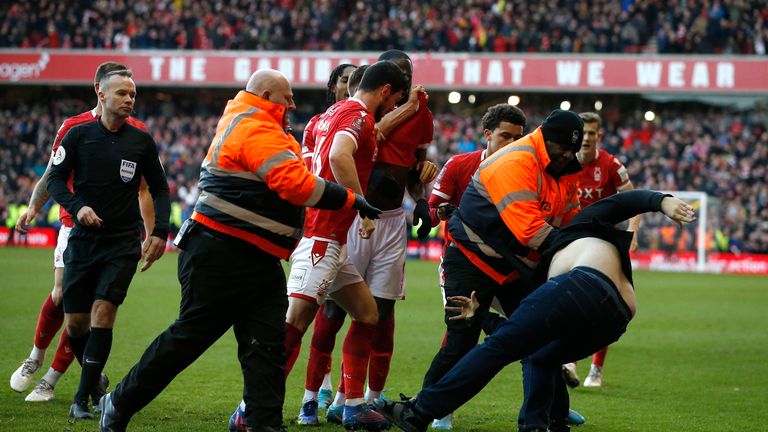 Soccer Football - FA Cup - Fourth Round - Nottingham Forest v Leicester City - The City Ground, Nottingham, Britain - February 6, 2022 A Leicester City fan is detained by stewards after invading the pitch REUTERS/Craig Brough
