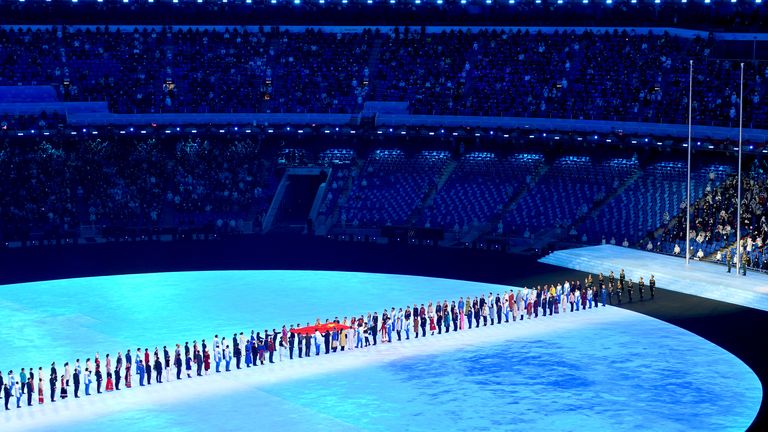 The national flag of the People&#39;s Republic of China is passed along prior to being raised during the opening ceremony of the Beijing 2022 Winter Olympic Games at the Beijing National Stadium in China.