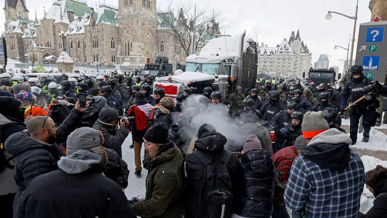 Kanadische Polizisten treffen Demonstranten auf dem Parliament Hill, während sie daran arbeiten, die Normalität in der Hauptstadt wiederherzustellen, während Lastwagen und Demonstranten die Innenstadt mehr als drei Wochen lang besetzen, um gegen Pandemiebeschränkungen in Ottawa, Ontario, Kanada, zu protestieren, 19. Februar 2022. REUTERS / Blair Gable