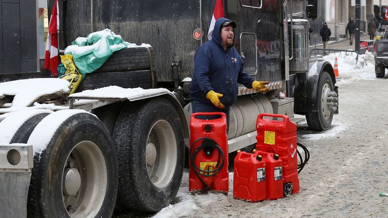 A person stands beside jerry gas cans, as truckers and supporters continue to protest coronavirus disease (COVID-19) vaccine mandates