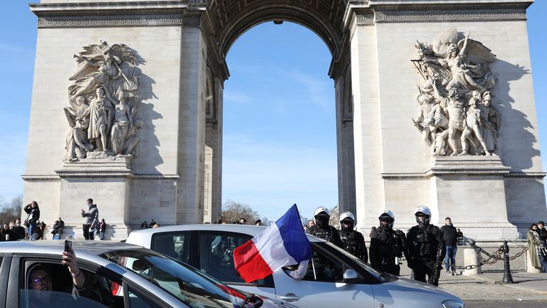 Protesters part of a convoy drives past the Arc de Triomphe on the Champs-Elysees avenue, Saturday, Feb.12, 2022 in Paris. Paris police intercepted at least 500 vehicles attempting to enter the French capital in defiance of a police order to take part in protests against virus restrictions inspired by the Canada&#39;s horn-honking "Freedom Convoy." (AP Photo/Adrienne Surprenant)


