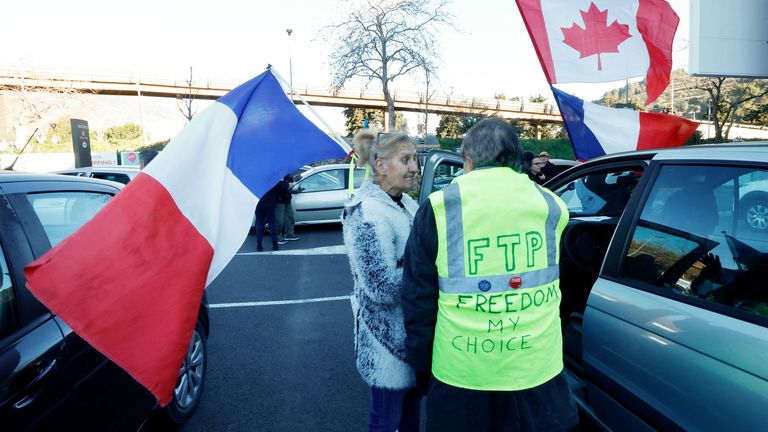 French activists hold French and Canadian flag before the start of their "Convoi de la liberte" (The Freedom Convoy), a vehicular convoy protest converging on Paris to protest coronavirus disease (COVID-19) vaccine and restrictions in Nice, France, February 9, 2022. REUTERS/Eric Gaillard
