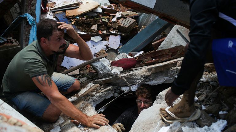 Men look for bodies amongst the rubble