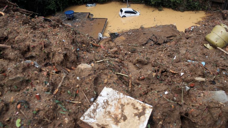 Une voiture est submergée sur le site d'un glissement de terrain à Morro da Oficina 
