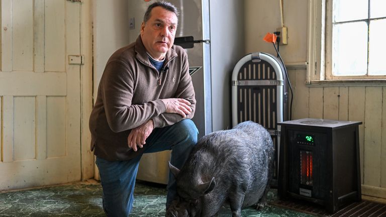 Wyverne Flatt who is fighting to keep his pot-bellied pig Ellie as an emotional support animal poses for a photograph at his home Wednesday, Feb. 2, 2022, in Canajoharie, N.Y. Village officials consider Ellie a farm animal, and not allowed in the village. (AP Photo/Hans Pennink)


