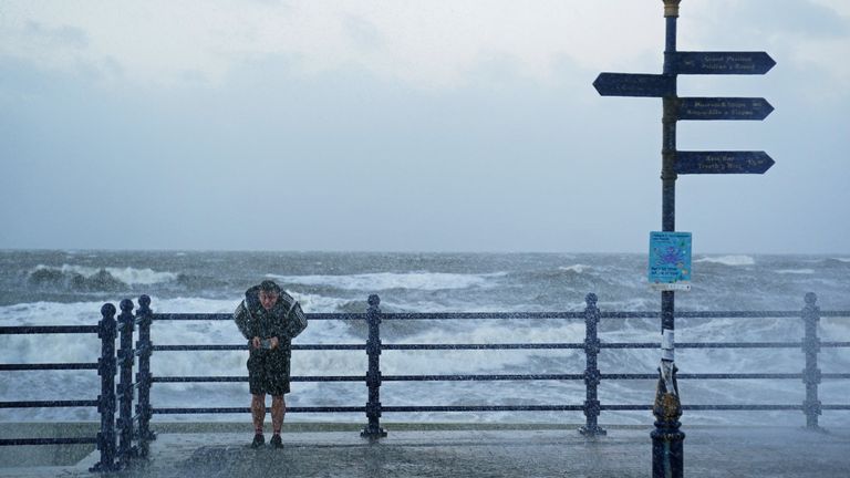 A person turns their back to the wind on the seafront in Porthcawl, Bridgend, Wales, as Storm Eunice hits the south coast, with attractions closing, travel disruption and a major incident declared in some areas, meaning people are warned to stay indoors. Picture date: Friday February 18, 2022.
