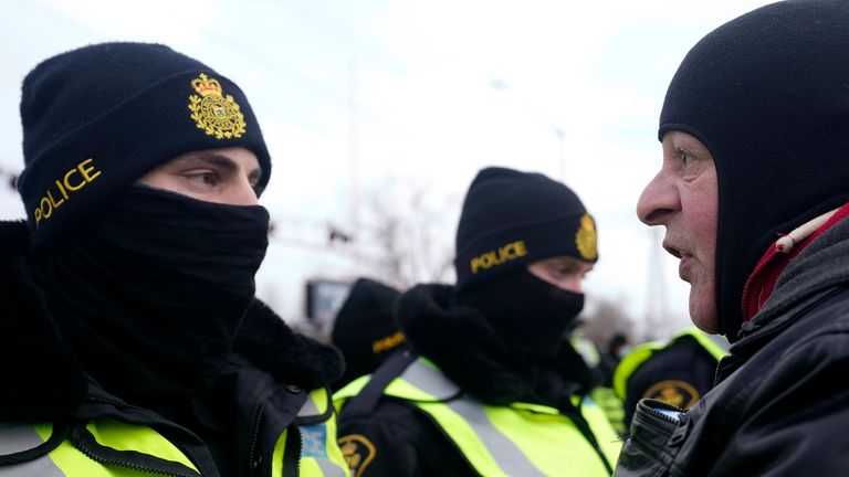 A protester yells at police officers as demonstrators prepare to leave in advance of police enforcing an injunction against their demonstration, which has blocked traffic across the Ambassador Bridge by protesters against COVID-19 restrictions, in Windsor, Ont., Saturday, Feb. 12, 2022. THE CANADIAN PRESS/Nathan Denette