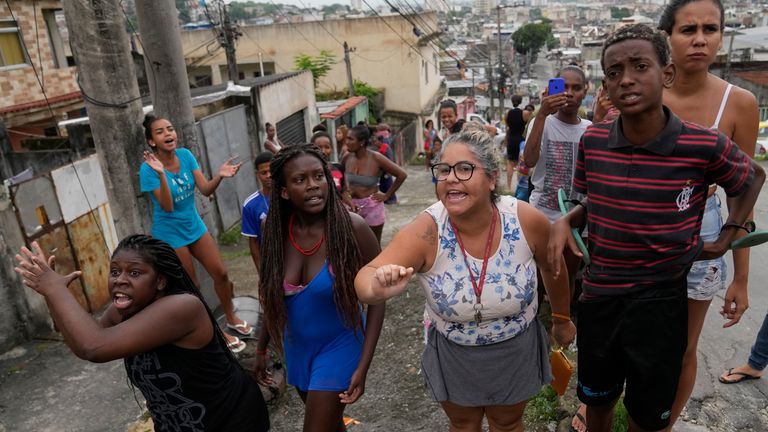 Residents protest during a police operation against drug traffickers at the Vila Cruzeiro slum in Rio de Janeiro, Brazil, Friday, Feb. 11, 2022. (AP Photo/Silvia Izquierdo)