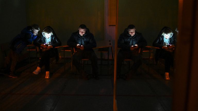 People use electronic devices in an air raid shelter in Kyiv, Ukraine February 25, 2022. REUTERS/Viacheslav Ratynskyi
