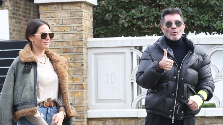Simon Cowell shows the broken arm he suffered in a bicycle injury last week as he and his partner, Lauren Silverman