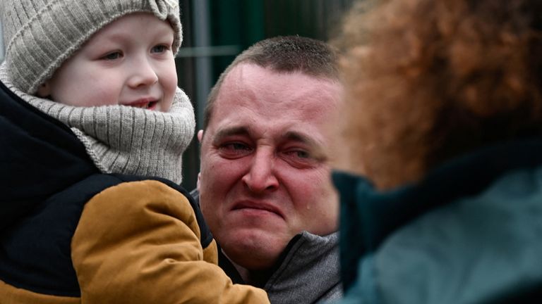 A man holding a child reacts as they arrive from Ukraine to Slovakia, after Russia launched a massive military operation against Ukraine, in Ubla, Slovakia, February 25, 2022. REUTERS/Radovan Stoklasa
