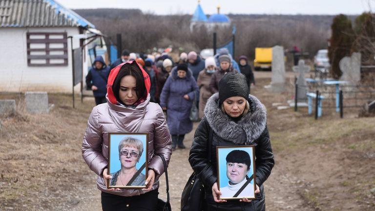Women carry portraits of school teachers Yelena Ivanova and Yelena Kudrik, who were killed by shelling, during a funeral at a cemetery in the separatist-controlled town of Horlivka (Gorlovka) in the Donetsk region, Ukraine, February 28, 2022. REUTERS/Stringer
