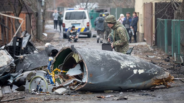 A Ukrainian soldier inspects debris of a downed aircraft in Kyiv, Ukraine